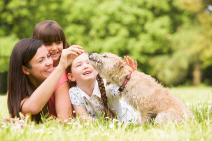 Mom and daughter on grass with dog