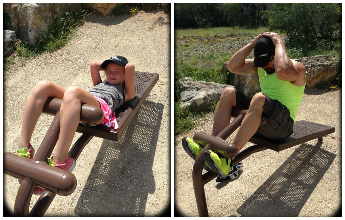 Father and daughter doing sit ups in the park
