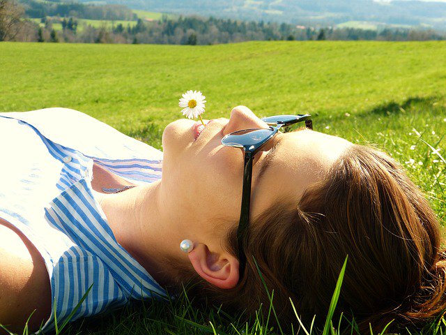 Woman laying in grass and looking at sky